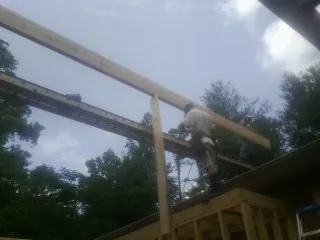 Carpenter setting a ridge beam over a new addition frame — Ice Dam Removal by Roofing Brothers in Green Mountain Falls