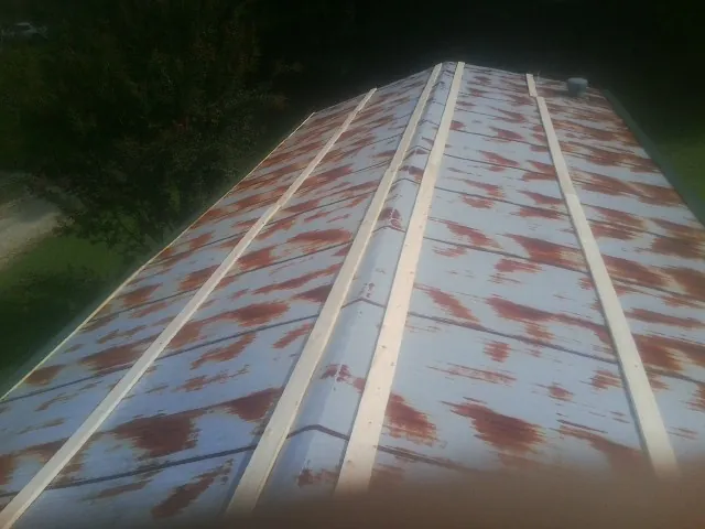 Rusted metal roof panels with new wood purlins before replacement — Storm Damage Roof Repair in Green Mountain Falls by Roofing Brothers