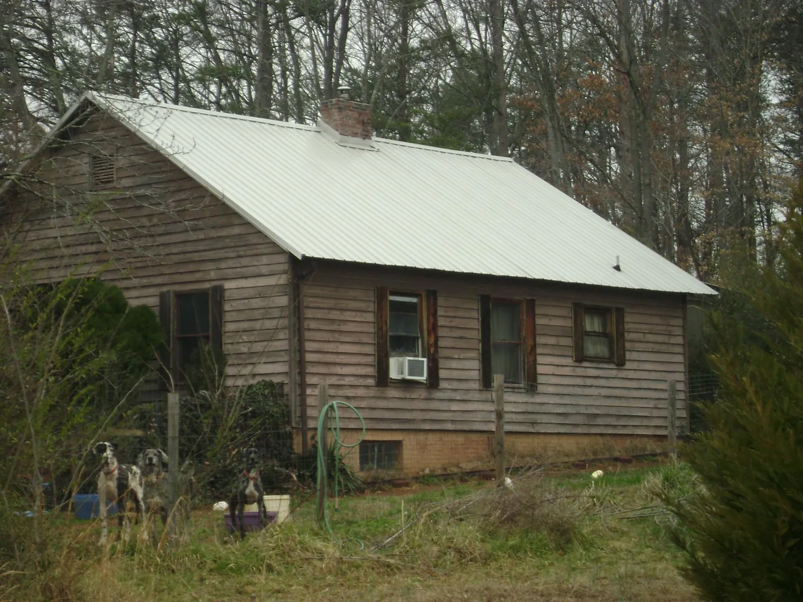 White metal roof on an old wood sided farmhouse, from a Metal Roof Installation job in Green Mountain Falls